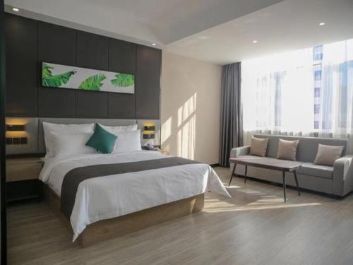 a bedroom with a large bed and a couch at Thank Inn Chain Yulin Yuyang Jinsha Road in Yulin