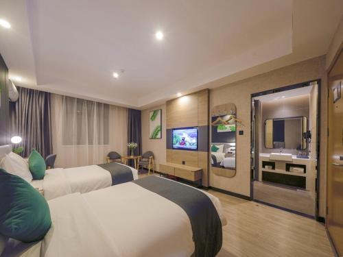 um quarto de hotel com duas camas e uma televisão em Thank Inn Chain Xianyang Renmin Road Central Plaza em Xianyang