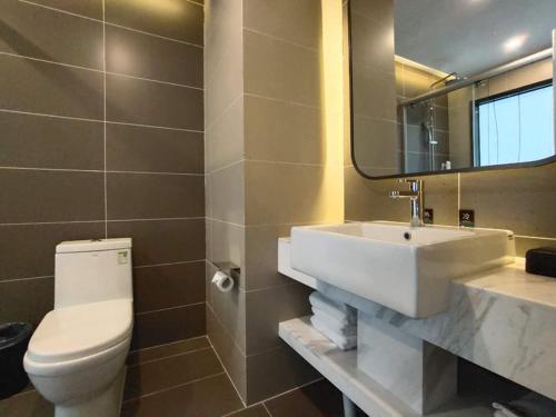 ein Badezimmer mit einem Waschbecken, einem WC und einem Spiegel in der Unterkunft Thank Inn Chain Shijiazhuang Railway Station East Plaza in Shijiazhuang