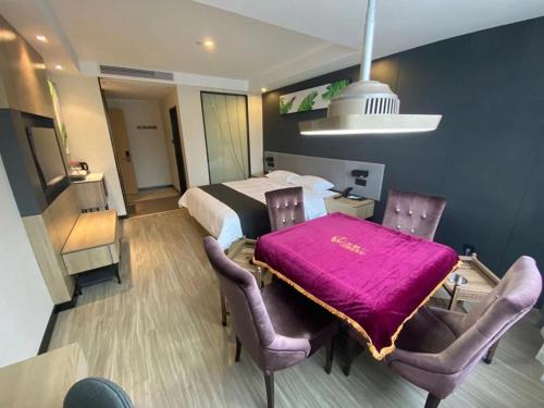 a bedroom with a bed and a table and chairs at Thank Inn Chain Yichang Sanxia Airport in Yichang