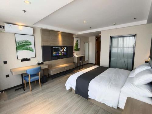 ein Hotelzimmer mit einem großen Bett und einem Schreibtisch in der Unterkunft Thank Inn Chain Shijiazhuang Railway Station East Plaza in Shijiazhuang