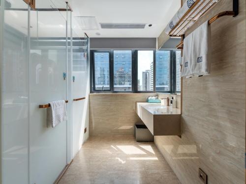 a bathroom with a shower and a sink and some windows at LanOu Hotel Shenzhen Luohu Ruipeng Building in Shenzhen