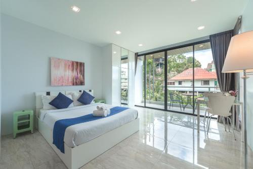 1 dormitorio con cama y ventana grande en 3-Story Pool Villa Katazhang UTK B3 just 7 min walk to Kata Beach en Kata