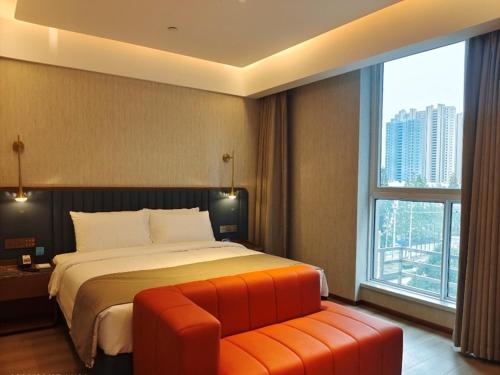 1 dormitorio con cama y ventana grande en LanOu Hotel Lianyungang Donghai High-speed Railway Station Crystal City, en Donghai