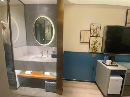 a bathroom with a sink and a mirror at LanOu Hotel Suqian Central Shopping Mall in Suqian