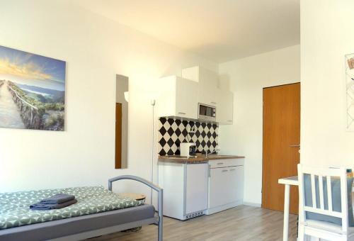 Kleines Zimmer mit einem Bett und einer Küche in der Unterkunft Hotel Stadt Völklingen in Citylage in Völklingen