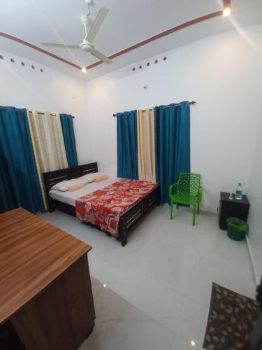 a bedroom with a bed and a green chair at New PALM BAY RESIDENCY in Varkala