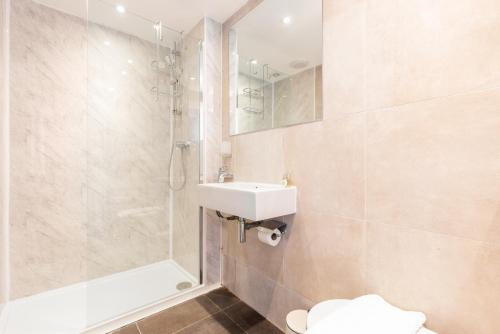 a bathroom with a sink and a shower and a toilet at The Primrose Hill Flats in London