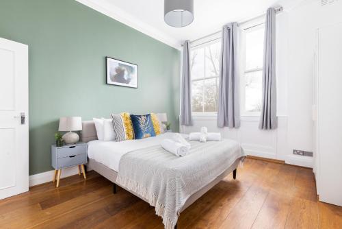 a white bedroom with a bed and a window at The Primrose Hill Flats in London