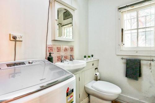 a bathroom with a toilet and a sink and a mirror at Vibrant House at the Center of Chippendale 2 E-Bikes Included in Sydney