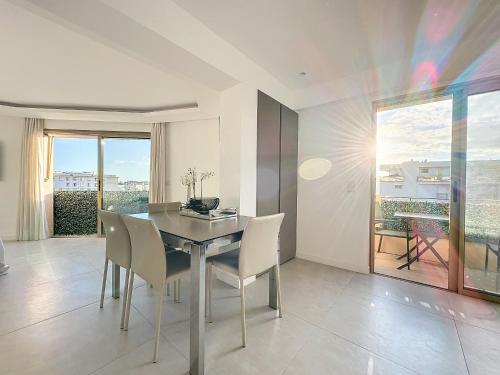 une salle à manger avec une table et des chaises et une fenêtre dans l'établissement Cannes Pointe Croisette - 2 couchages, à Cannes