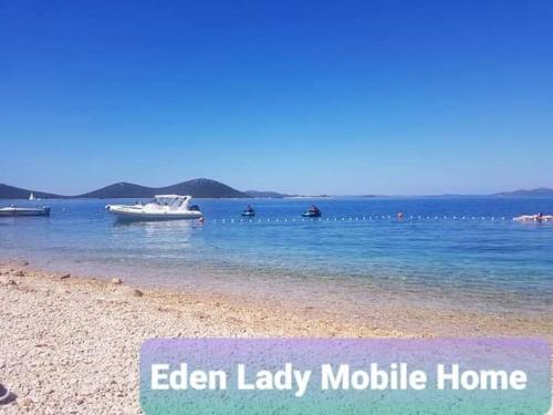 a beach with a boat in the water at Eden Lady Mobile Home, Croatia, Drage in Drage