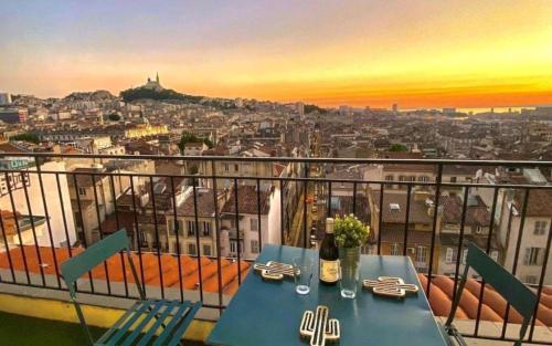 une table sur un balcon avec vue sur une ville dans l'établissement Belle vue de Notre Dame du Mont by Weekome, à Marseille
