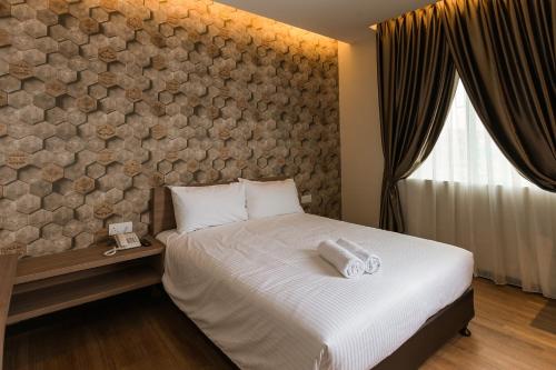 a bedroom with a bed and a stone wall at D Elegance Hotel in Nusajaya