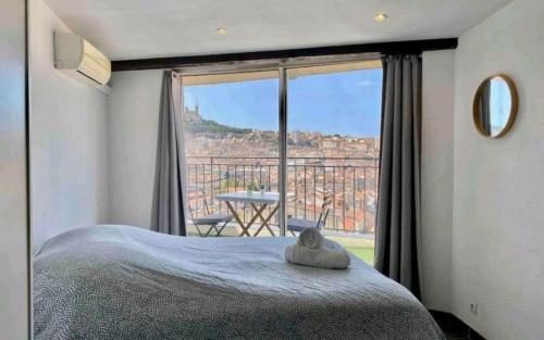 une chambre avec un lit et une grande fenêtre dans l'établissement Belle vue de Notre Dame du Mont by Weekome, à Marseille