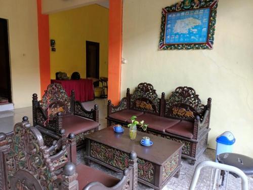 a living room with three chairs and a table at OYO 91232 Hotel Garuda in Sumenep