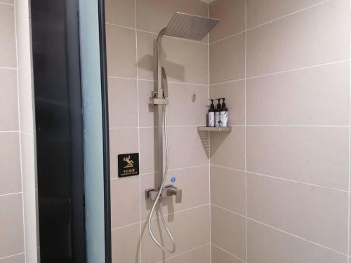 La salle de bains est pourvue d'une douche avec un pommeau de douche. dans l'établissement Thank Inn Chain Hotel Shangqiu Yongcheng Jinbo Grand Plaza, à Yongcheng