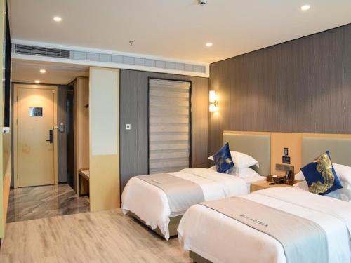 a hotel room with two beds in a room at Jiari Meidi Hotel Chaozhou Hanshan Normal University in Chaozhou