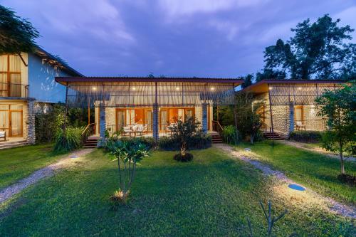 a house with a large yard in front of it at Sanctuary Chitwan National Park in Chitwan