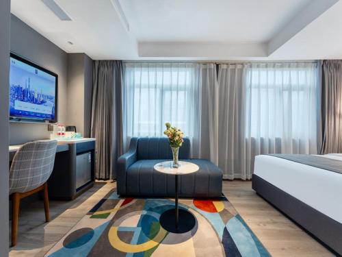 Habitación de hotel con cama, sofá y mesa en LanOu Hotel Shenzhen Luohu Ruipeng Building en Shenzhen