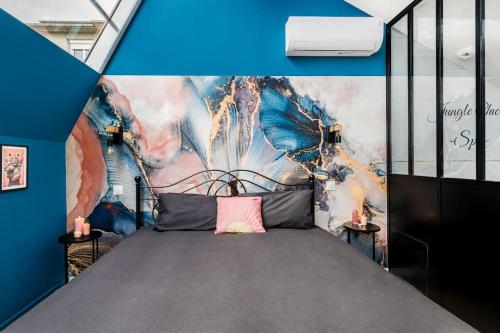 - une chambre avec un lit orné d'une peinture murale dans l'établissement Bienvenue à Jungle Chic, à Bourgoin-Jallieu