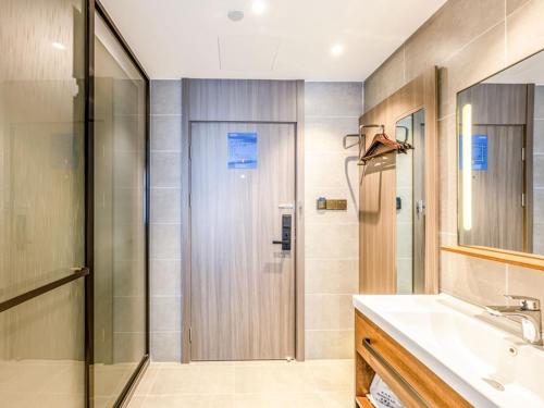 a bathroom with a shower and a sink at LanOu Hotel Langfang Gu'an Daxing Airport Wildlife Park in Langfang