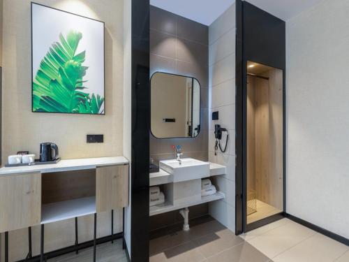 a bathroom with a sink and a mirror at Thank Inn Chain Foshan Gaoming Road in Gaoming