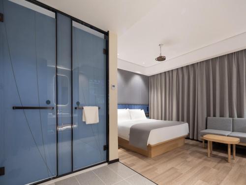 a hotel room with a bed and a sliding glass door at LanOu Hotel Yangquan Gymnasium in Yangquan