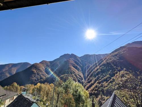 a view of a mountain with the sun in the sky at Wild Valley Puro Ticino 1 in Valle Onsernone in Crana