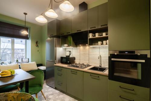 リヴィウにあるAlfa Apartments Halytska 9の緑の壁のキッチン(テーブル付)、キッチン(コンロ付)