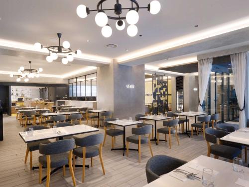 a dining room with tables and chairs and windows at Nagoya Kanko Hotel in Nagoya
