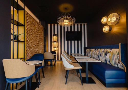 a dining room with a blue bench and chairs at ibis Nancy Centre Stanislas in Nancy