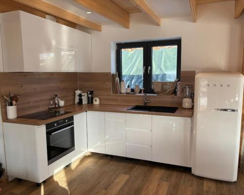 eine Küche mit weißen Schränken und einem weißen Kühlschrank in der Unterkunft NEW chalet de standing premium in Senones