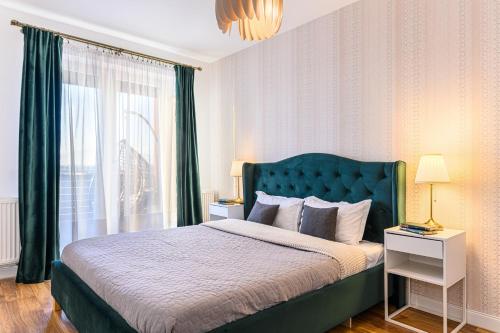 a bedroom with a bed with a green headboard and a window at KOA - Sunlight Apartment in Braşov