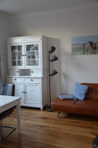 ein Wohnzimmer mit einem Sofa und einer Kommode in der Unterkunft Villa Scherz - stilvoll, zentral, ruhig, EG in Borkum