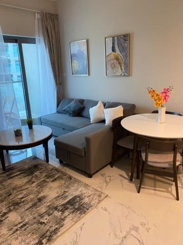 salon z kanapą i stołem w obiekcie StoneTree - Cozy and Modern 1 BR w Dubaju