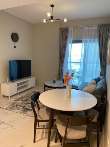 a living room with a table and a tv at StoneTree - Cozy and Modern 1 BR in Dubai
