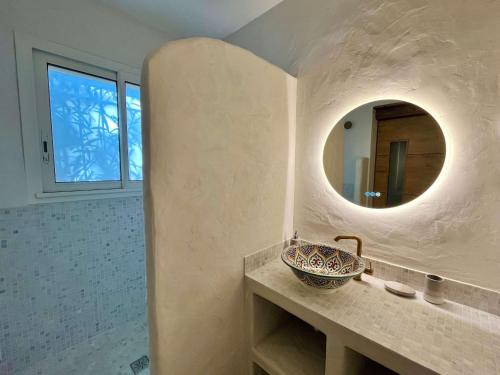 uma casa de banho com um lavatório e um espelho em Kallinera em Porto-Vecchio