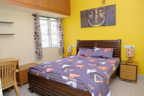 - une chambre avec un grand lit avec une tête sur le mur dans l'établissement Aakruti- centrally located home in malleswaram, à Bangalore