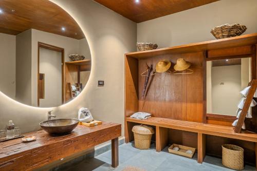 a bathroom with a wooden sink and a mirror at Sanctuary Resort, Chitwan National Park, Nepal in Chitwan