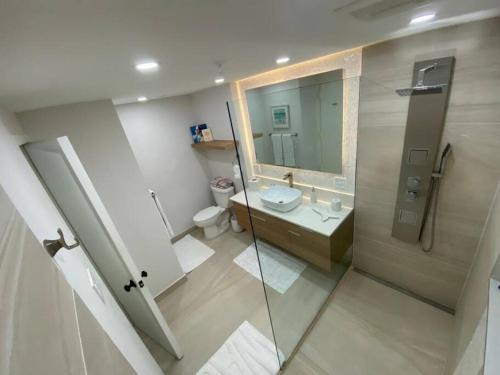 a bathroom with a sink and a toilet and a mirror at Luxury Beachfront 2 Bedroom at Wyndham Rio Mar, PR in Luquillo