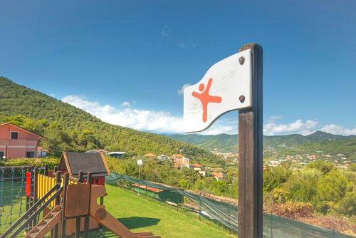 a sign for a playground with a mountain in the background at Villino Garden & Pool in Marina dʼAndora