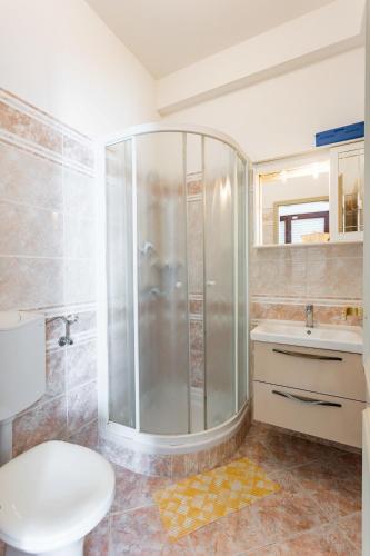 a bathroom with a shower and a toilet and a sink at Villa Amigo in Podstrana