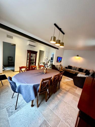ein Wohnzimmer mit einem Tisch und einem Sofa in der Unterkunft Le refuge Champenois in Verneuil