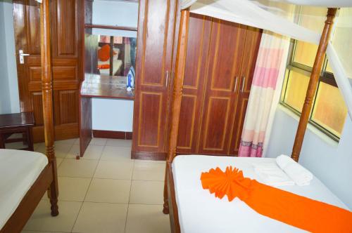 a bedroom with a bed with an orange decoration on it at Roma Stays - Splendid Kariba at Sunset Paradise Shanzu with a Swimming Pool in Mombasa