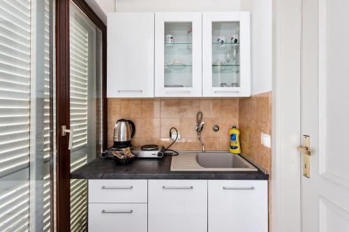 a kitchen with white cabinets and a sink at Villa Amigo in Podstrana