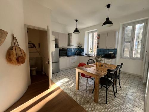 une cuisine avec une table et des chaises dans une pièce dans l'établissement Superbe appartement spacieux, calme, central, à Toulon
