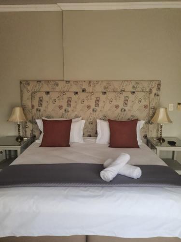 a bedroom with a large white bed with two pillows at Pecan Farm Guesthouse in Louis Trichardt