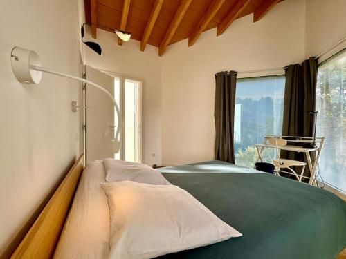 - une chambre avec un lit vert et une grande fenêtre dans l'établissement Villa d'architecte, piscine privative, Vico Corse, à Vico