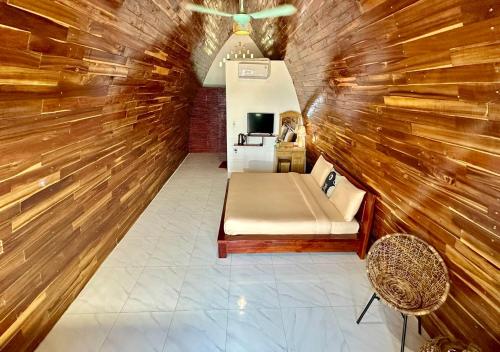 a small room with a bed and a chair at Hoa Loi Resort Phú Yên in Song Cau